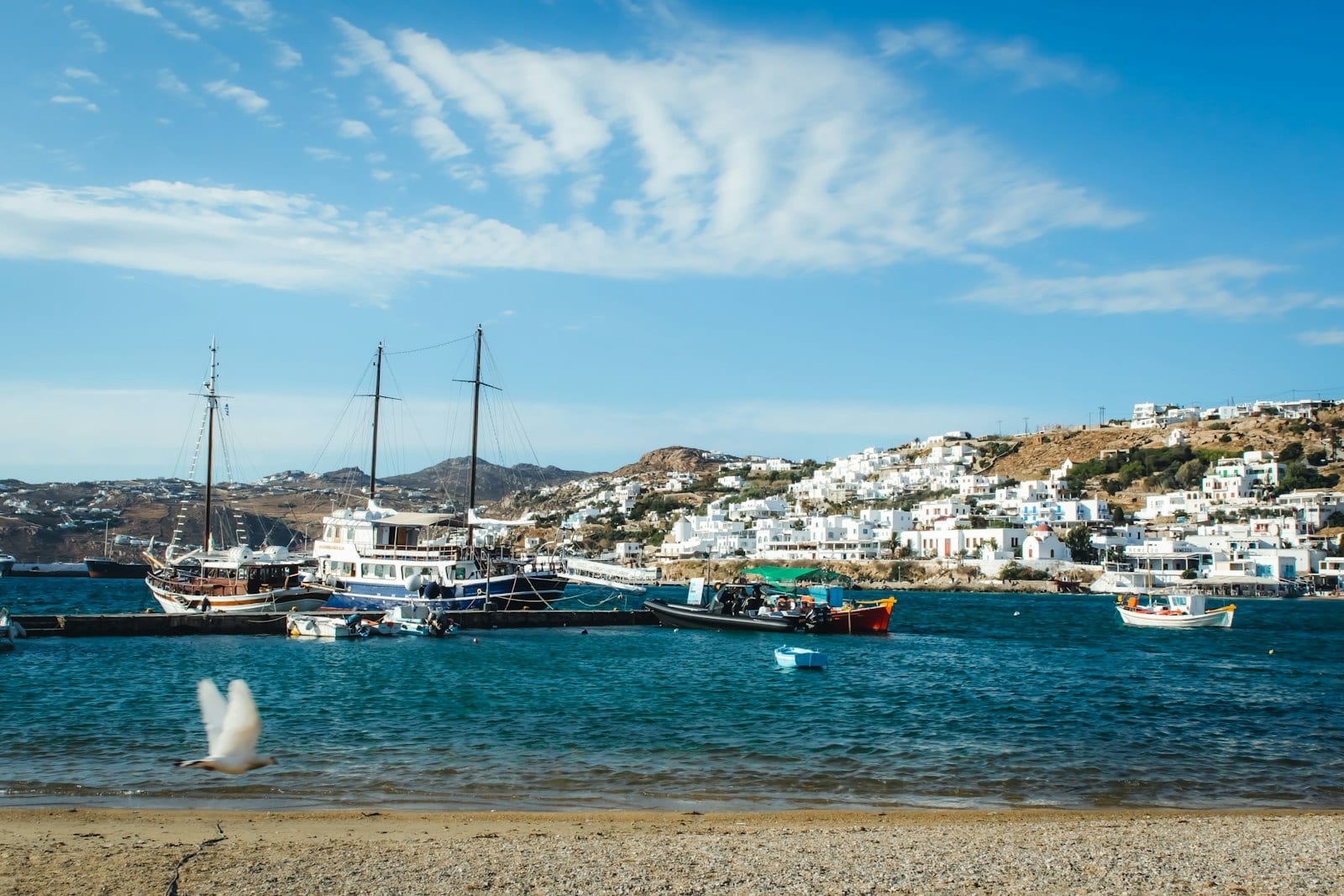 Boats moored in Mykonos harbour under blue sky